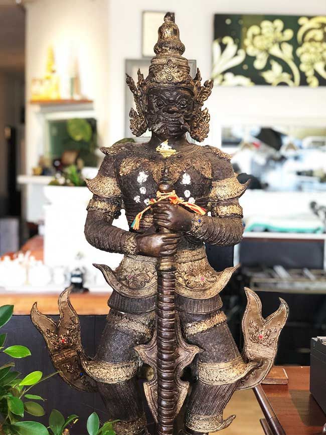 A statue of a warrior is sitting on a table in a room.