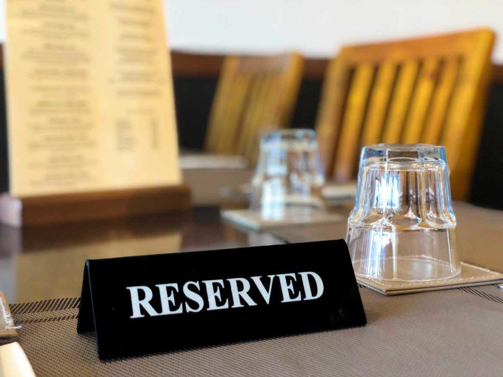 A reserved sign is sitting on a table with glasses.