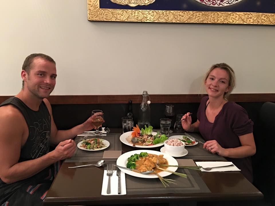 A man and a woman are sitting at a table with plates of food.