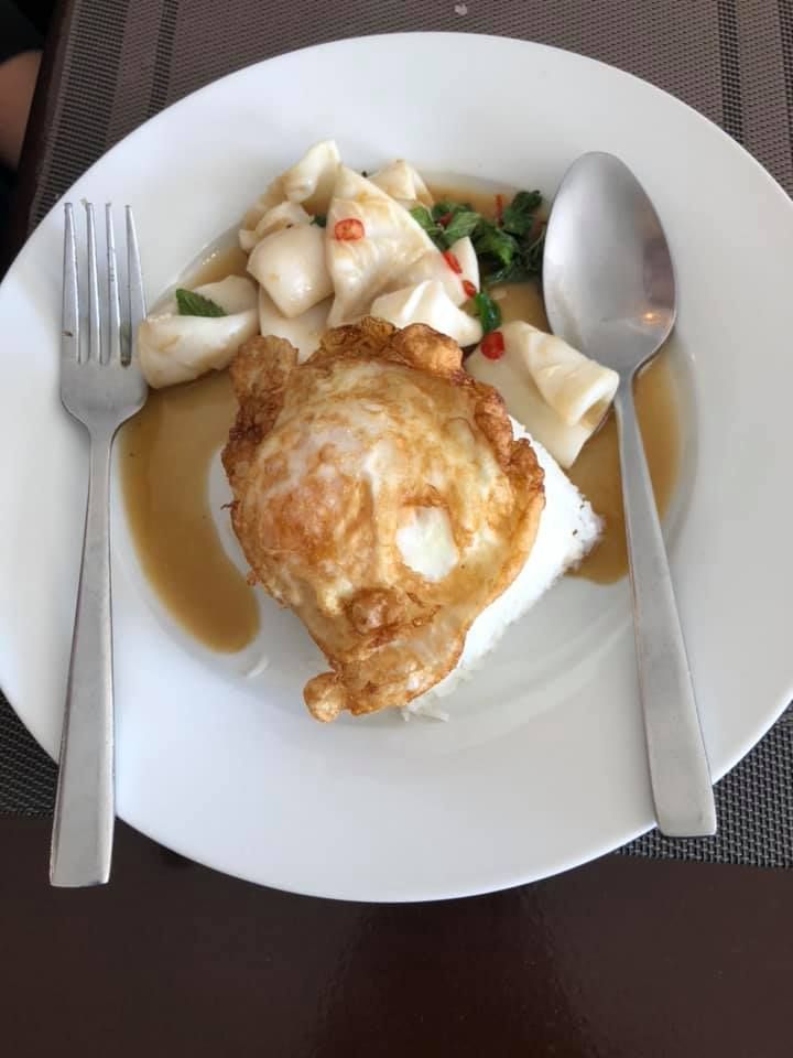 A plate of food with a fork and spoon on a table.