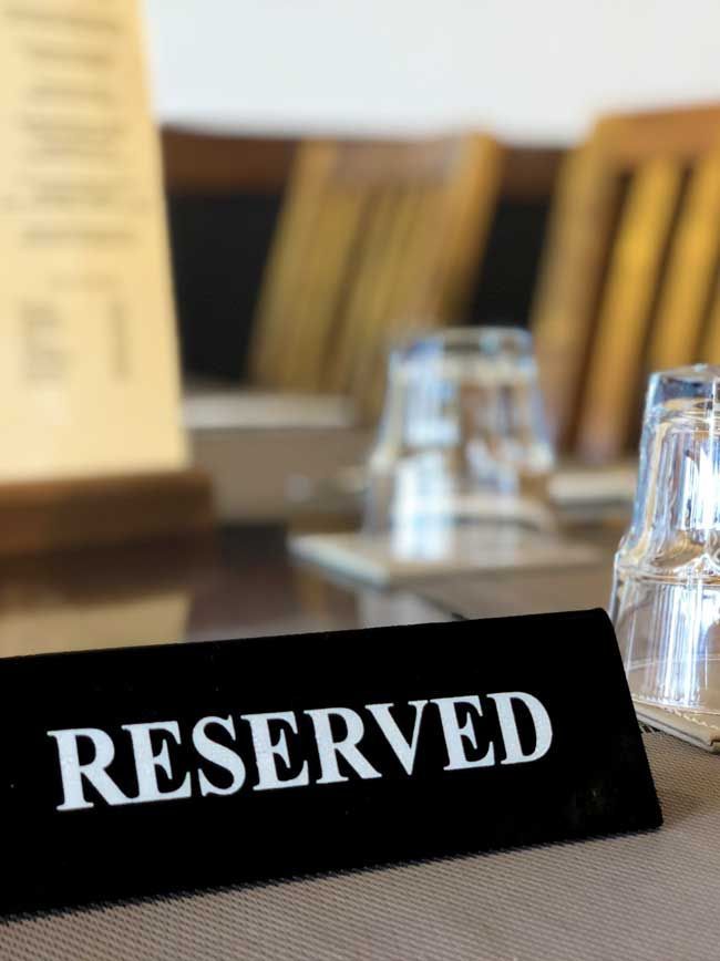 A reserved sign sits on a table with glasses