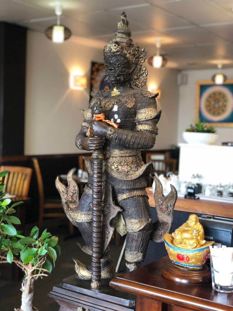 A statue of a warrior is sitting on a table in a restaurant.