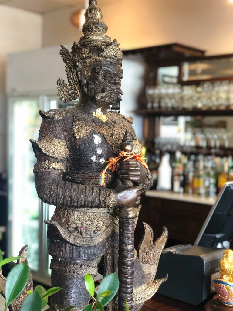 A statue of a warrior is sitting on a table in a restaurant.