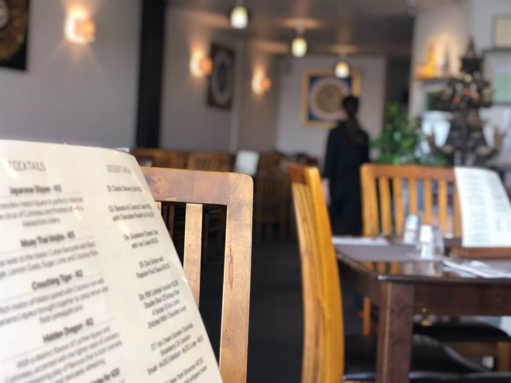A menu is sitting on a chair in a restaurant.