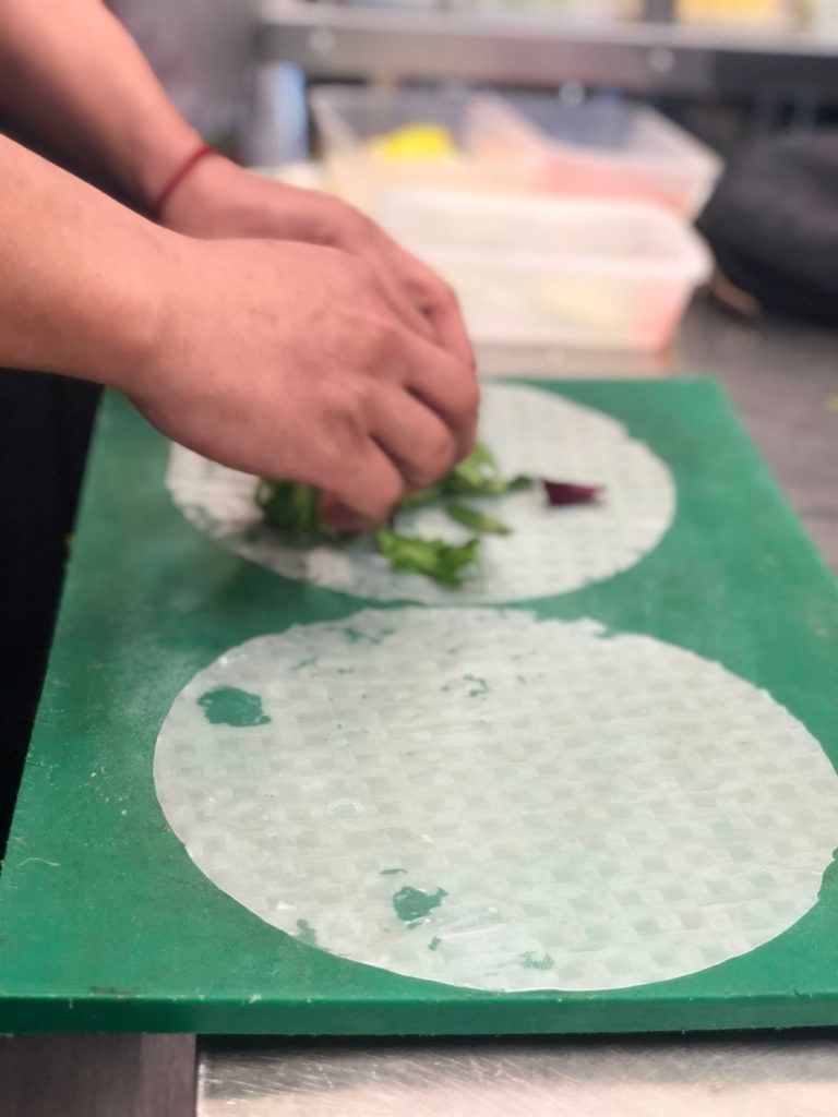 A person is cutting vegetables on a green cutting board