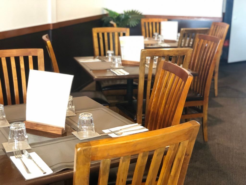 A restaurant with tables and chairs set up for a meal