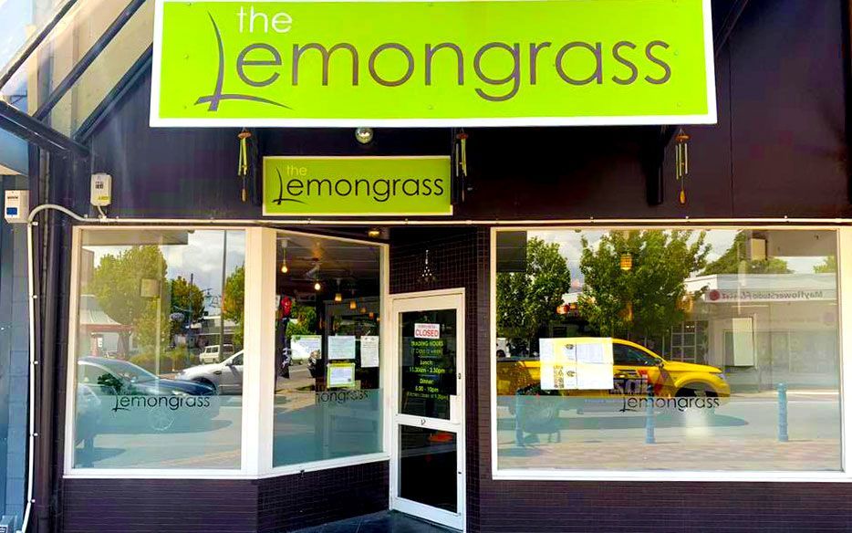 The front of a restaurant called the lemongrass with a green sign above the door.