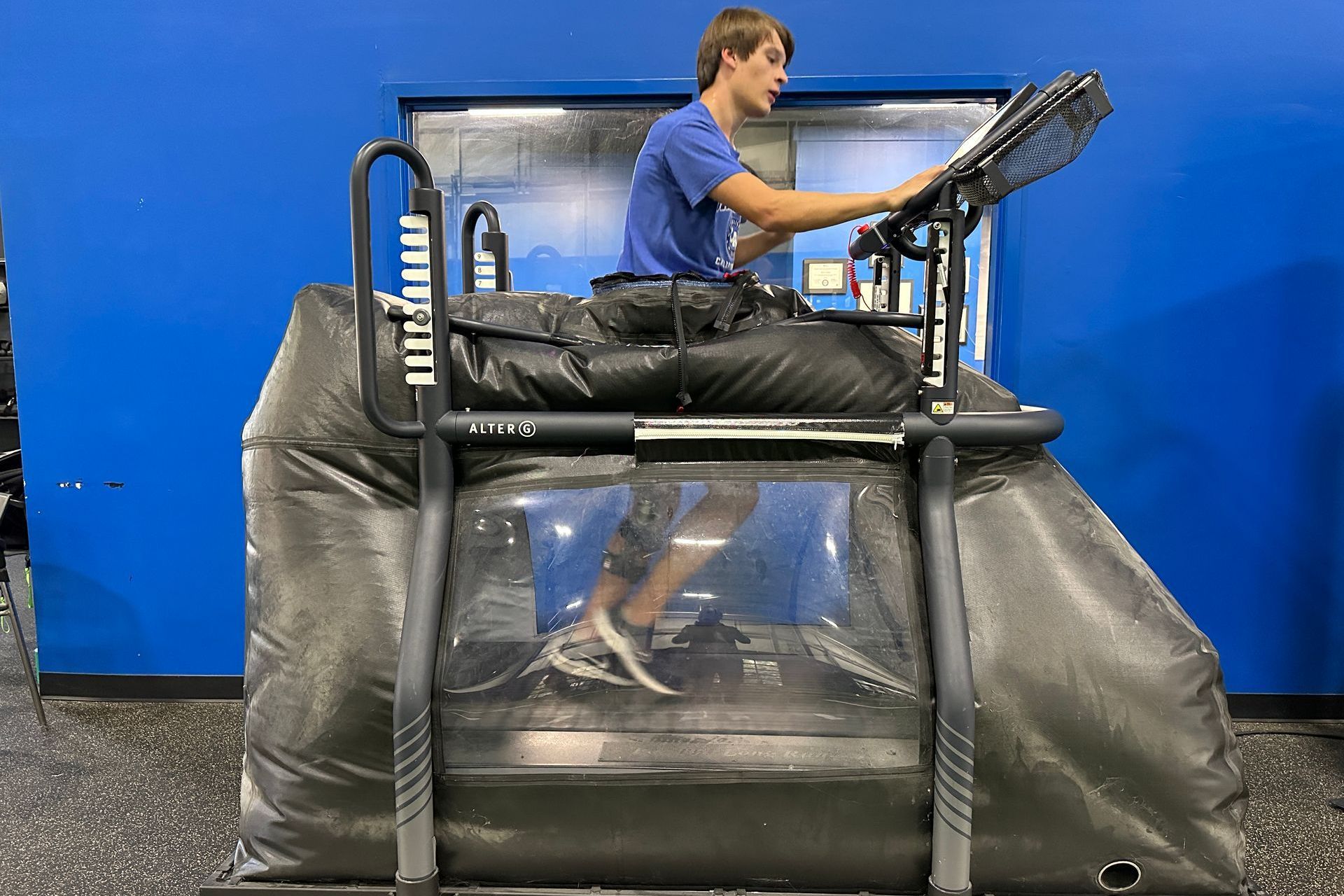 A man is sitting on a treadmill in a gym.