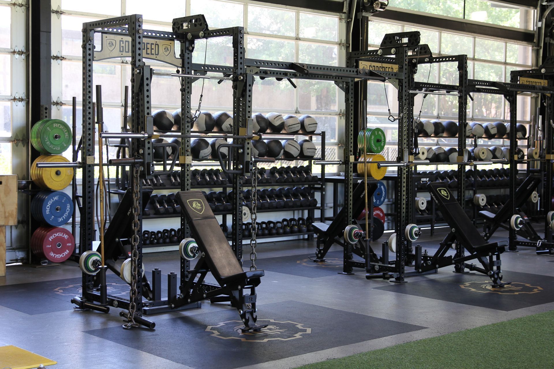 A gym filled with lots of exercise equipment and dumbbells.