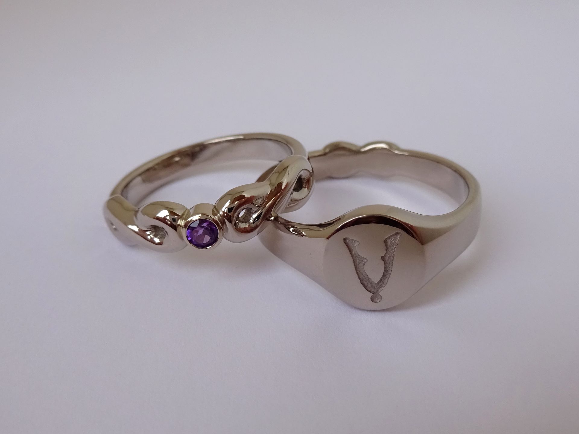 Witgouden trouwringen met logo veteranen, paarse edelsteen amethist en symbool voor de eeuwigheid.