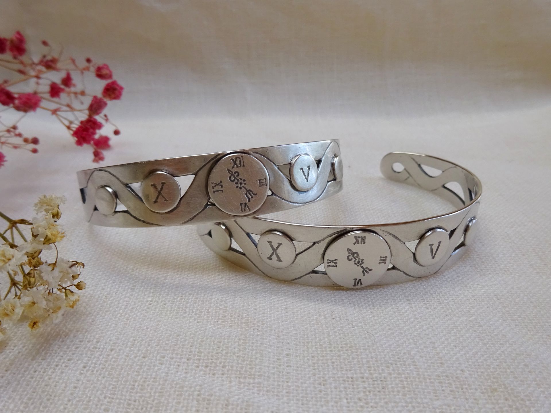 Armbanden van zilver met o.a. een klok, datum en symbool voor de kinderen.