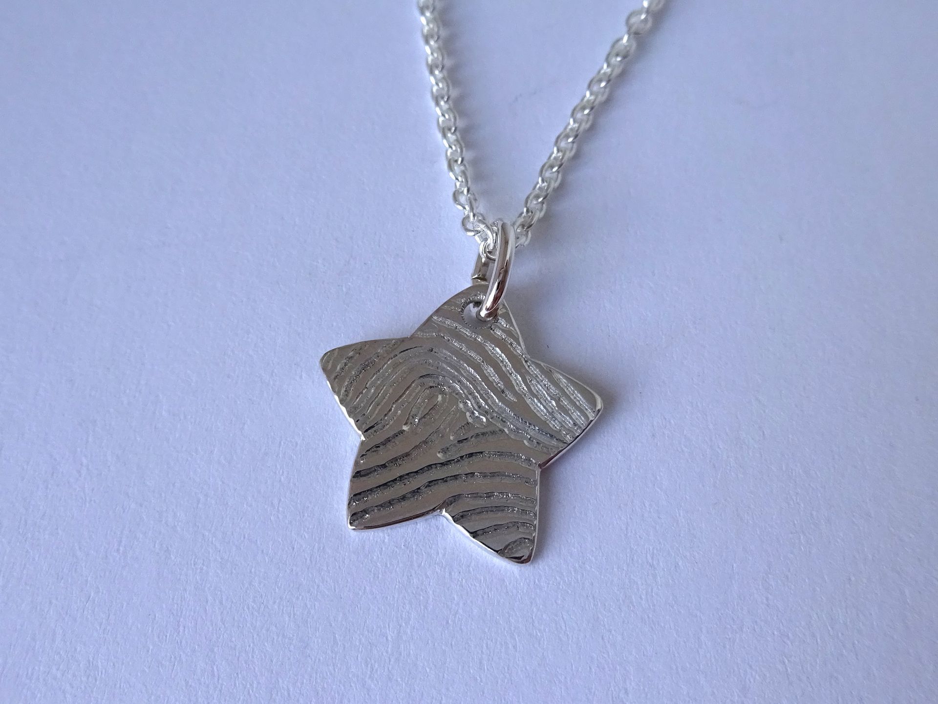Ketting met sterretje van zilver met hand gegraveerde vingerafdruk. Herinnerings sieraad.