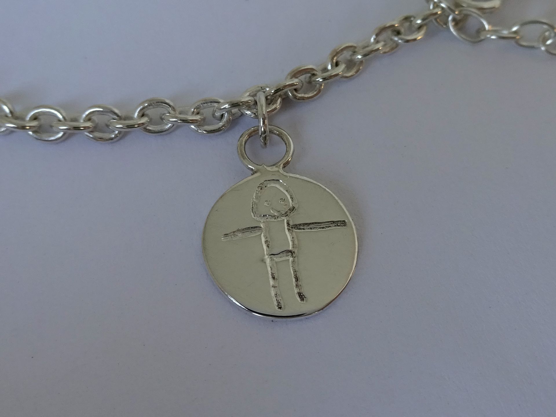 Op maat gemaakt bedeltje van een kindertekening.