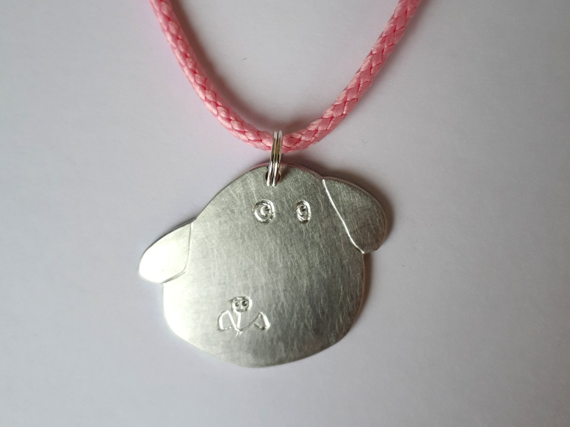 Bedel voor aan kinderketting van een getekende hond.