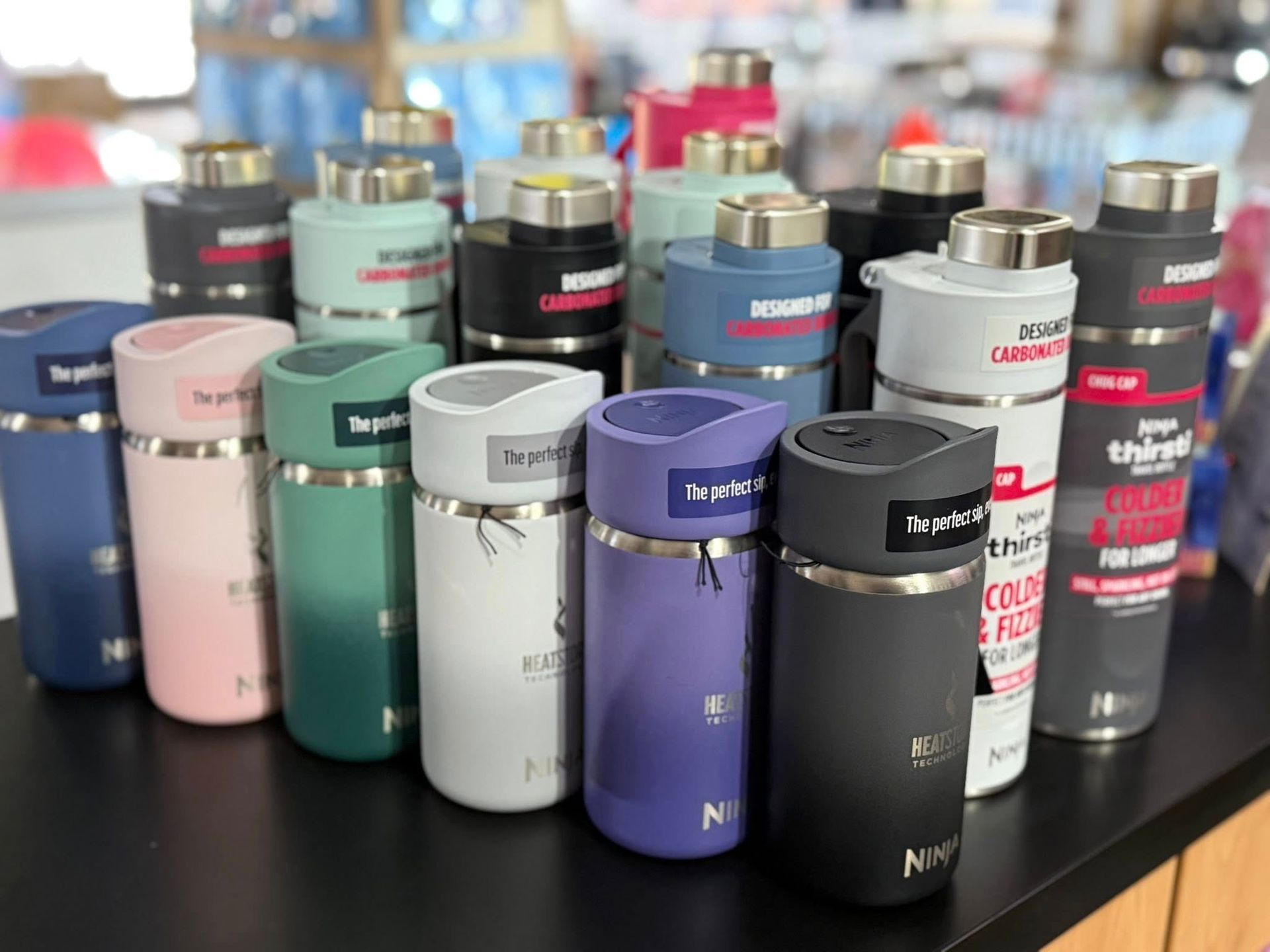 A Collection of Various Coloured Insulated Water Bottles on a Store Shelf — Enterprise Electrics NT Pty Ltd in Tennant Creek, NT
