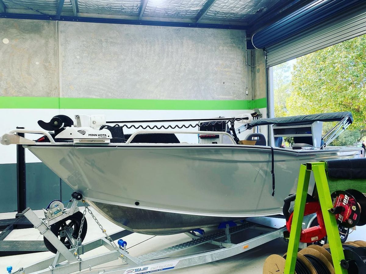 Silver Boat on a Trailer Inside a Workshop With Green and Gray Accents — All Coast Auto Solutions in Noosaville, QLD