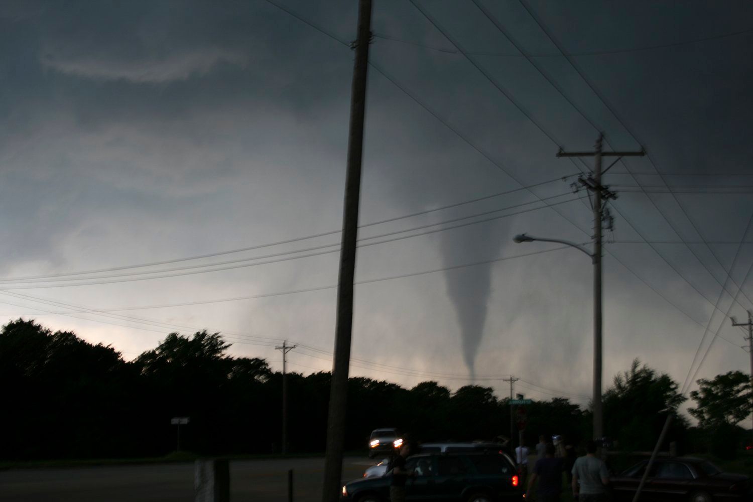 A group of people standing in front of a tornado