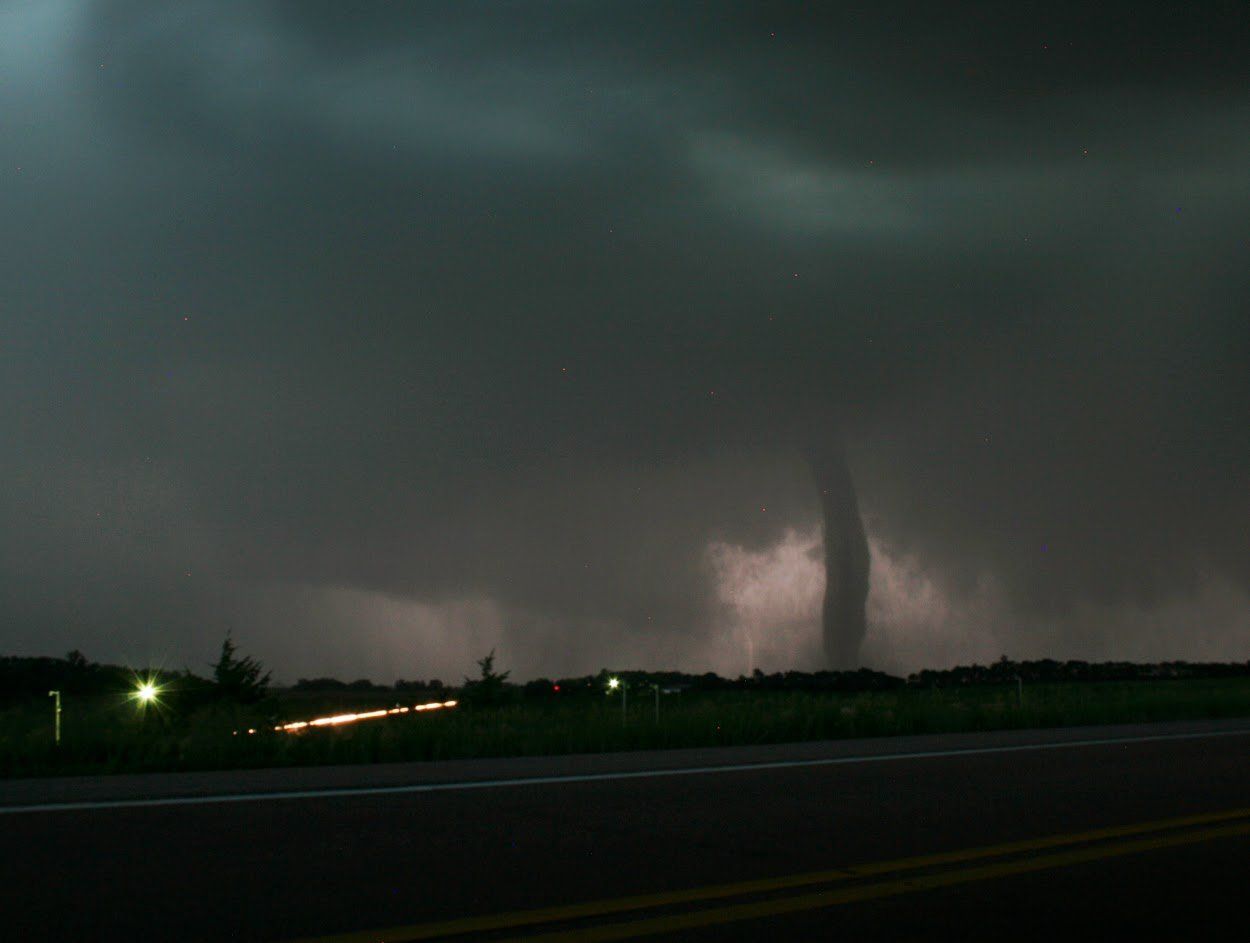 A tornado is coming down the road at night