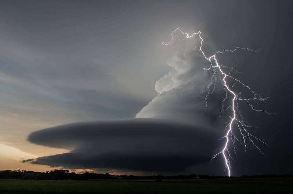 A lightning bolt is coming out of a cloud in the sky.