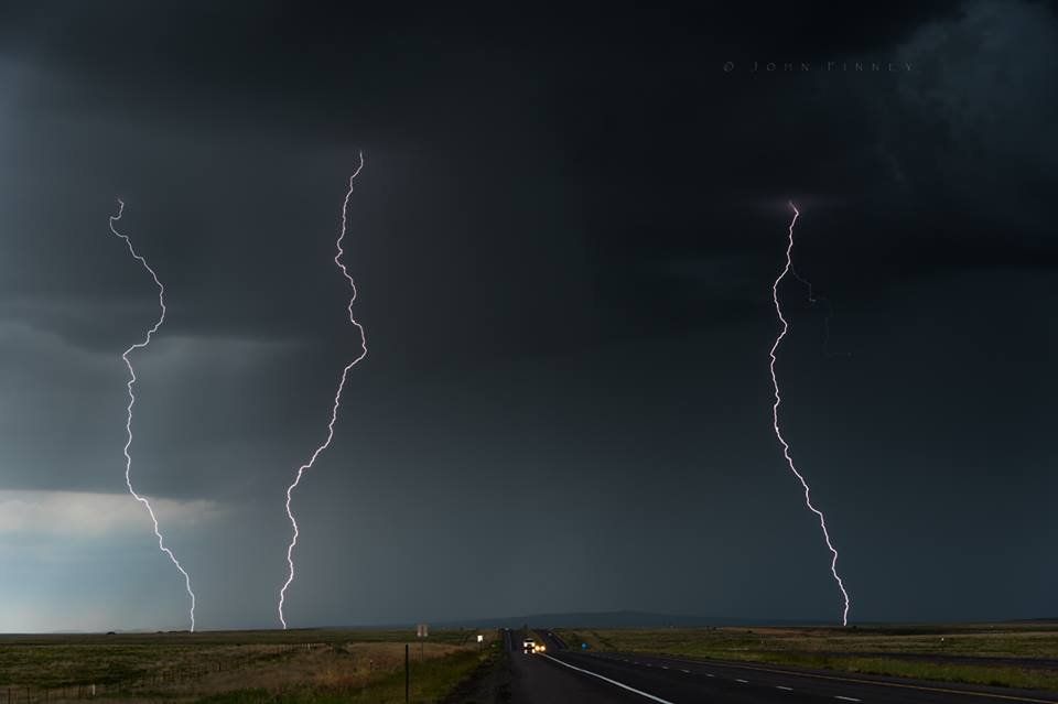 Lightning strikes over a highway during a storm