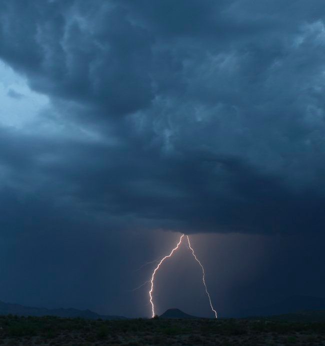 A lightning bolt is strikes in the sky during a storm.