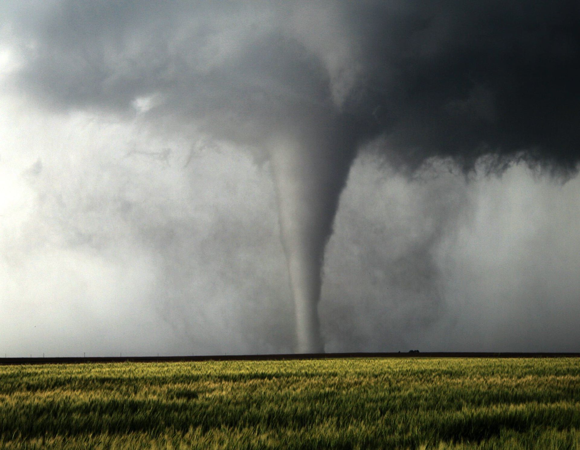 A tornado is moving through a field of grass.