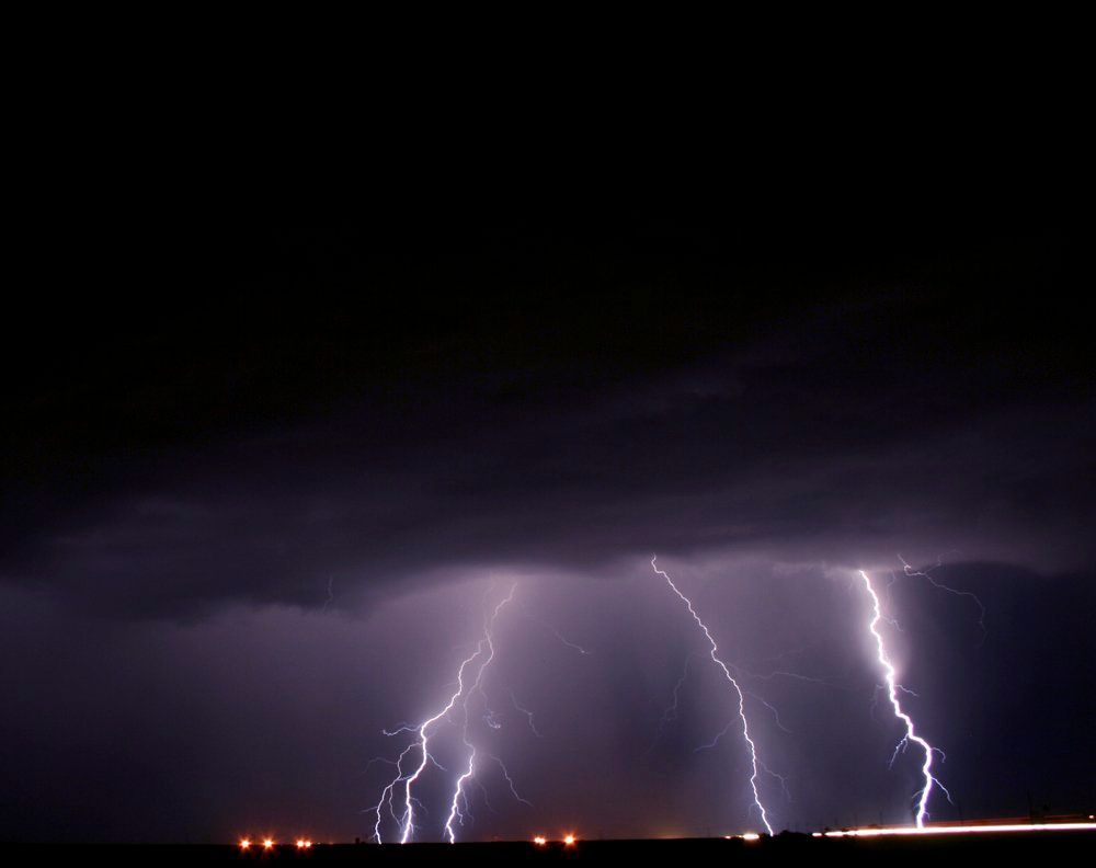 Lightning strikes during a storm in the night sky