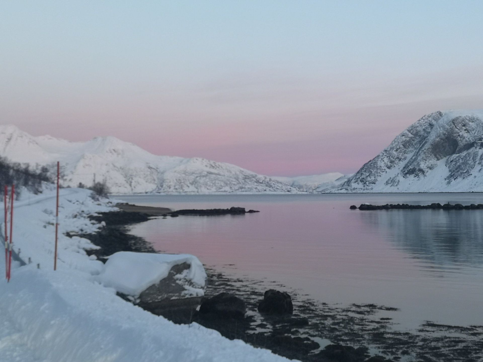 A snowy shoreline with mountains in the background