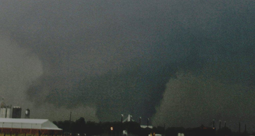 A tornado is moving through the sky over a city