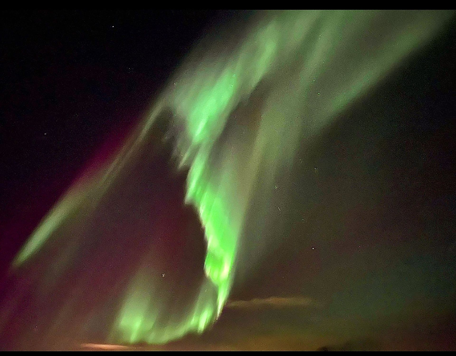 The aurora borealis is glowing brightly in the night sky.
