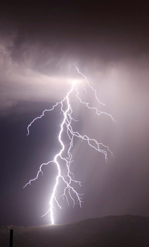 A lightning bolt is visible in the night sky