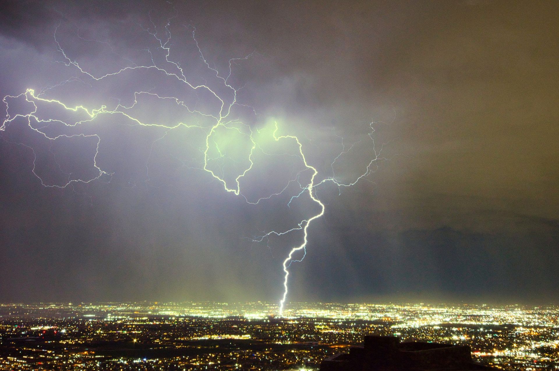 A lightning bolt strikes over a city at night