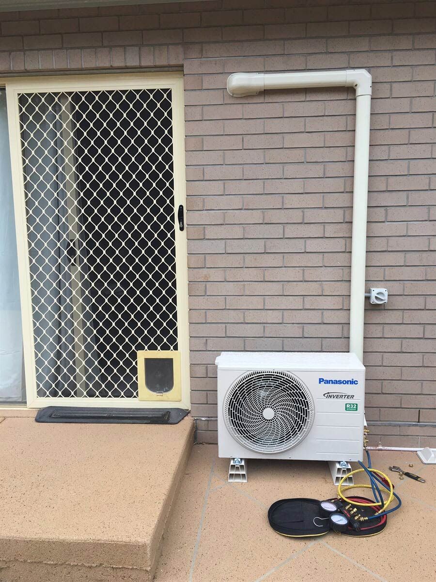 An Outdoor Air Conditioner Condenser Beside the Door - Refrigeration Service in South Burnett, QLD