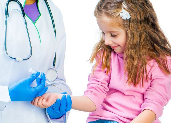 A little girl is getting an injection from a doctor.