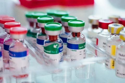 A bunch of bottles of vaccine are sitting on a table.