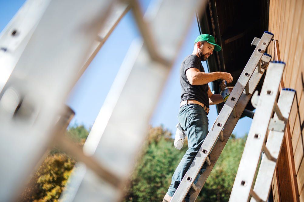 Worker on the Ladder Painting Wall — Bolingbrook, IL — A & D Quality Painting