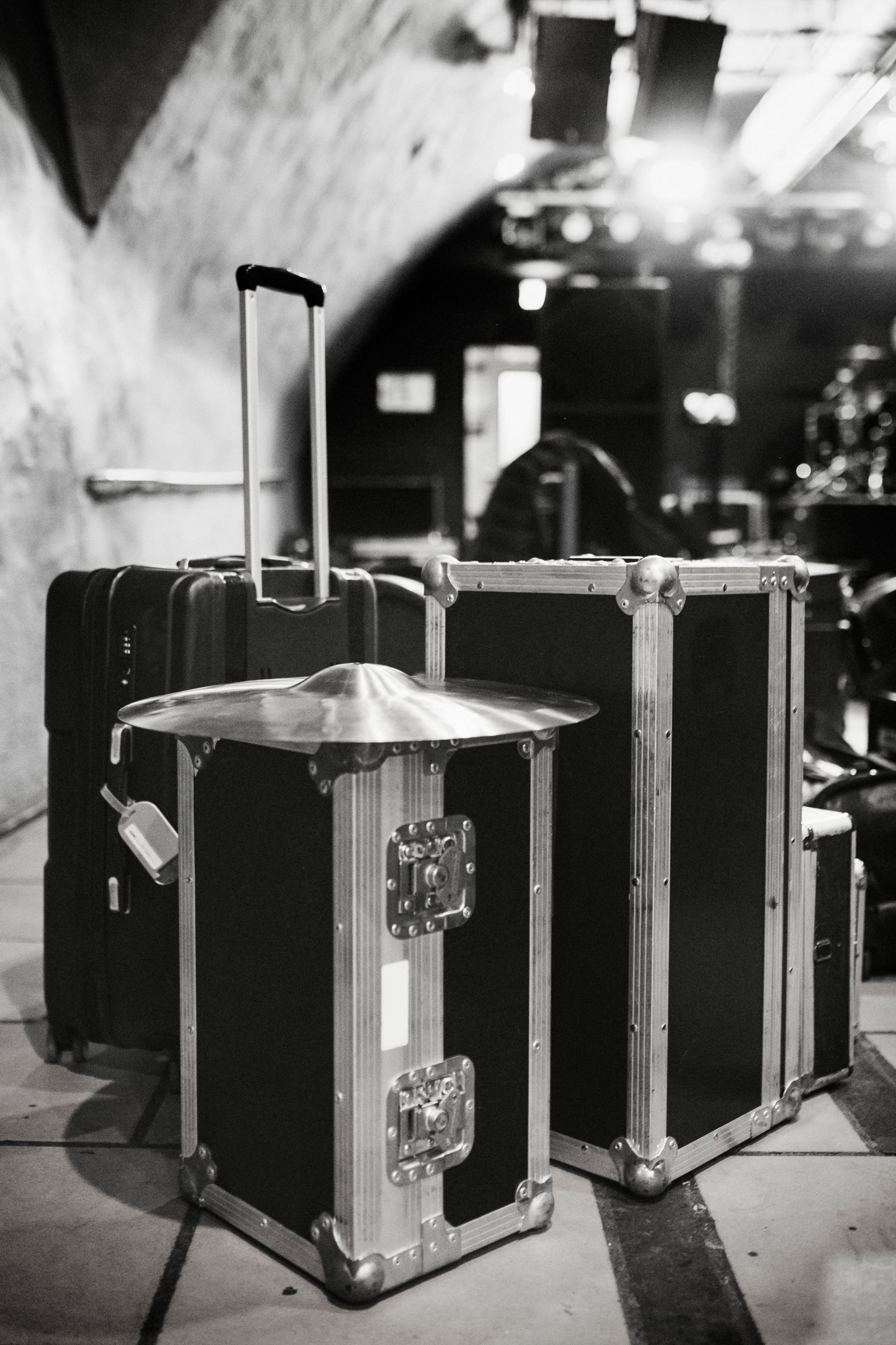 Black and white photo of travel cases, likely backstage at a venue.