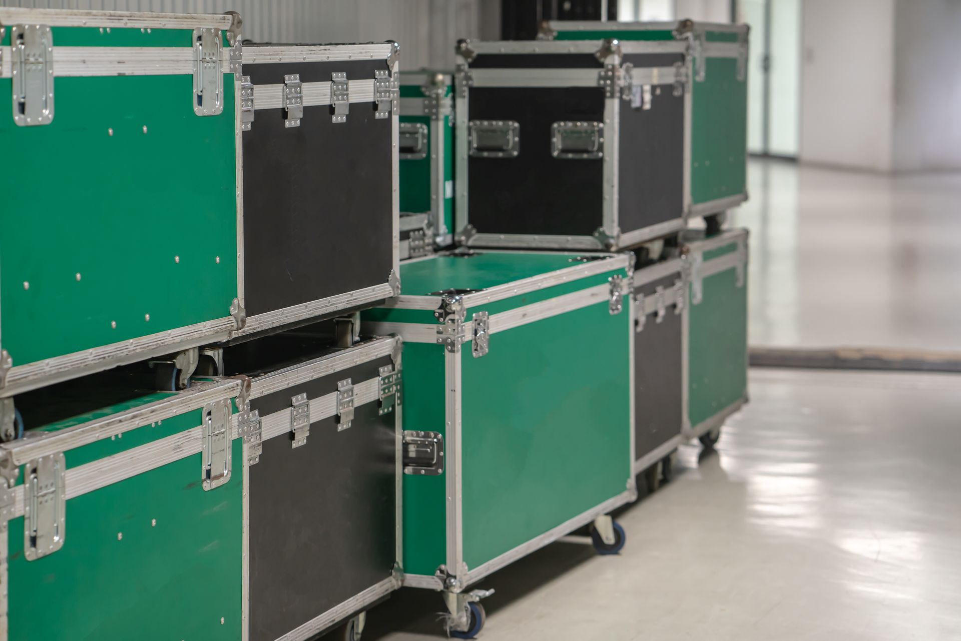 Green and black equipment cases stacked in a storage space.