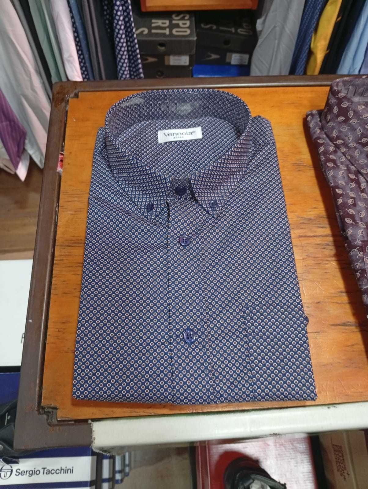 Camisa de vestir para hombre con estampado burdeos, doblada sobre una superficie de madera, expositor de tienda.
