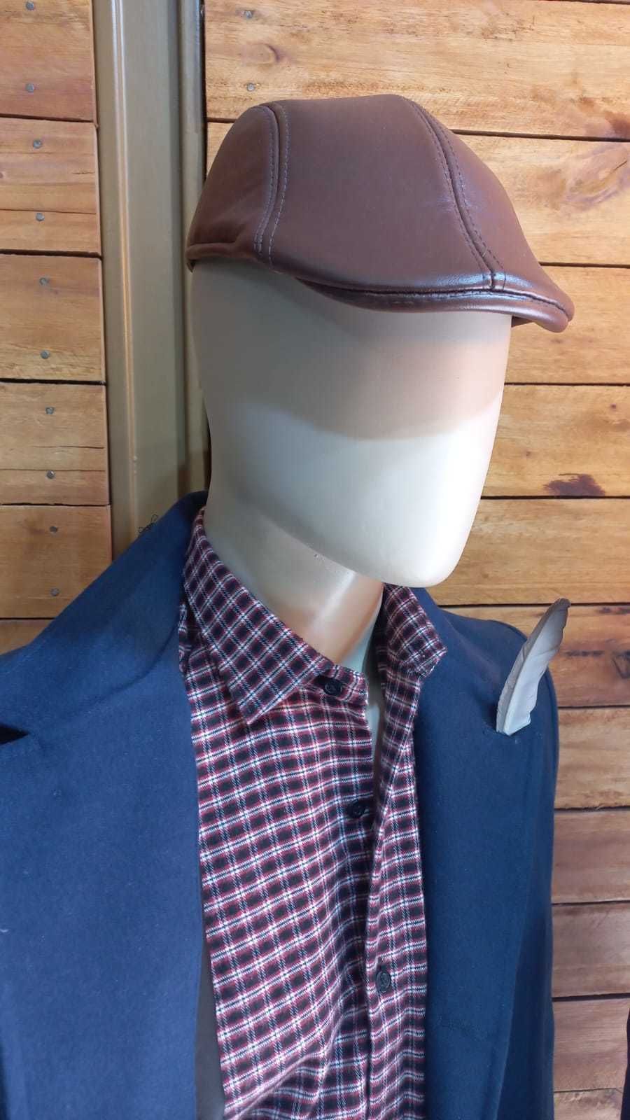 Maniquí con abrigo azul, camisa a cuadros y gorra marrón