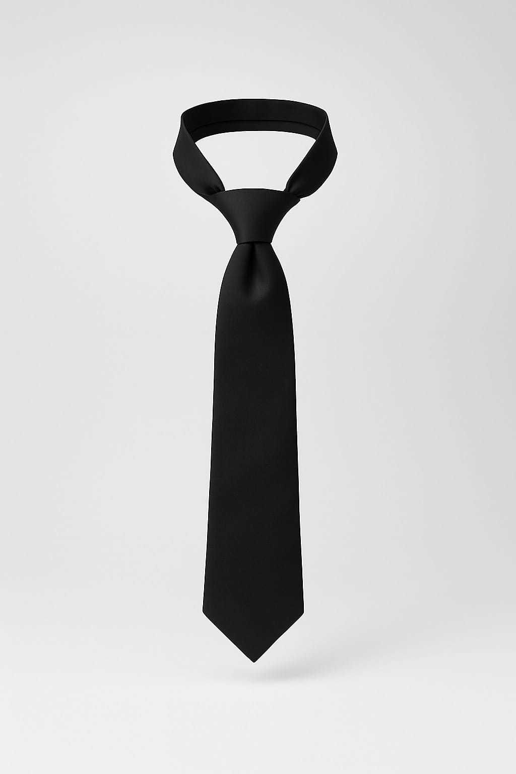 Corbata negra anudada y colgada verticalmente.