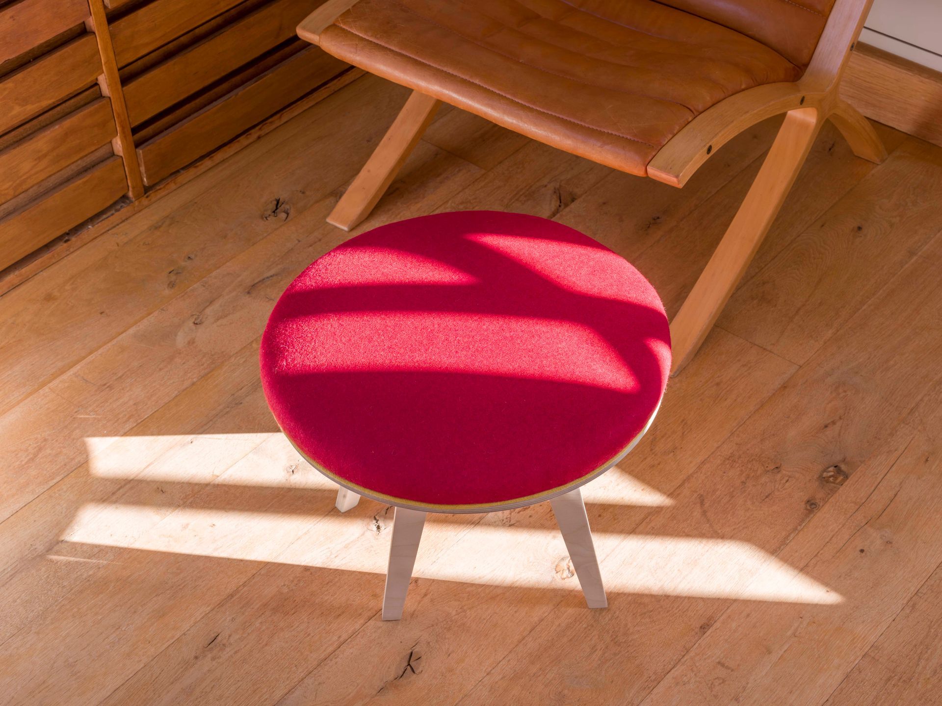 Red wool upholstered modern round birch ply footstool