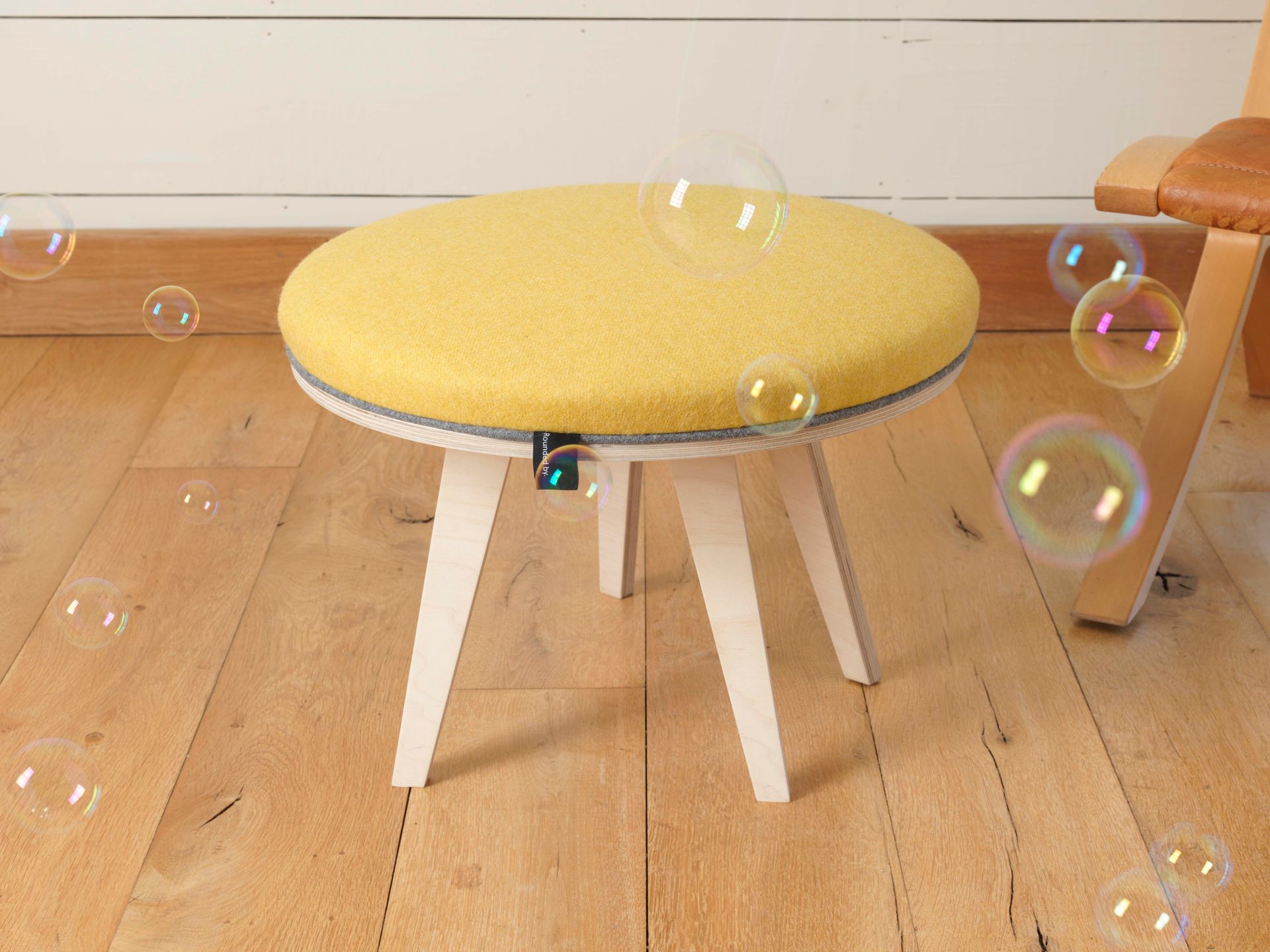 Yellow wool upholstered modern round birch ply footstool