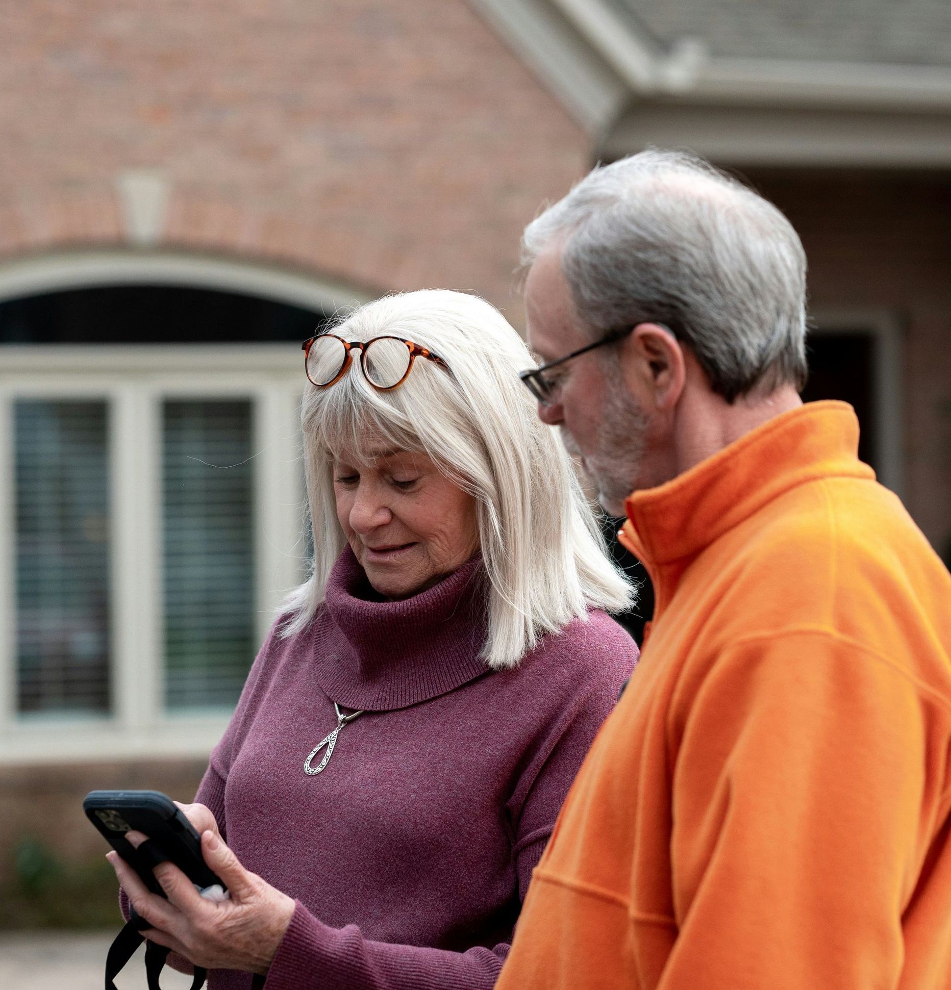 A man and a woman are looking at a cell phone