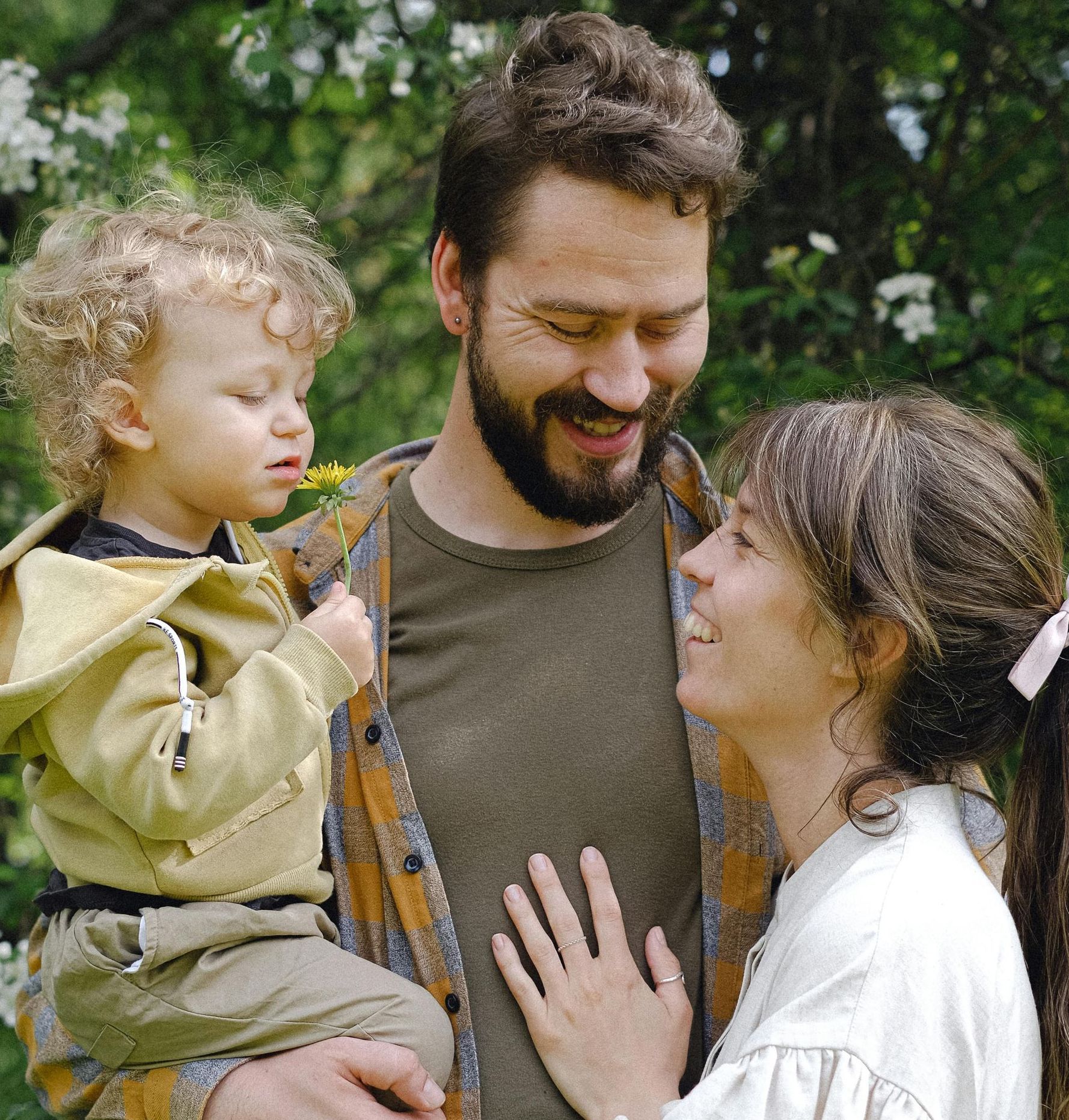 A man with a beard is holding a child in his arms