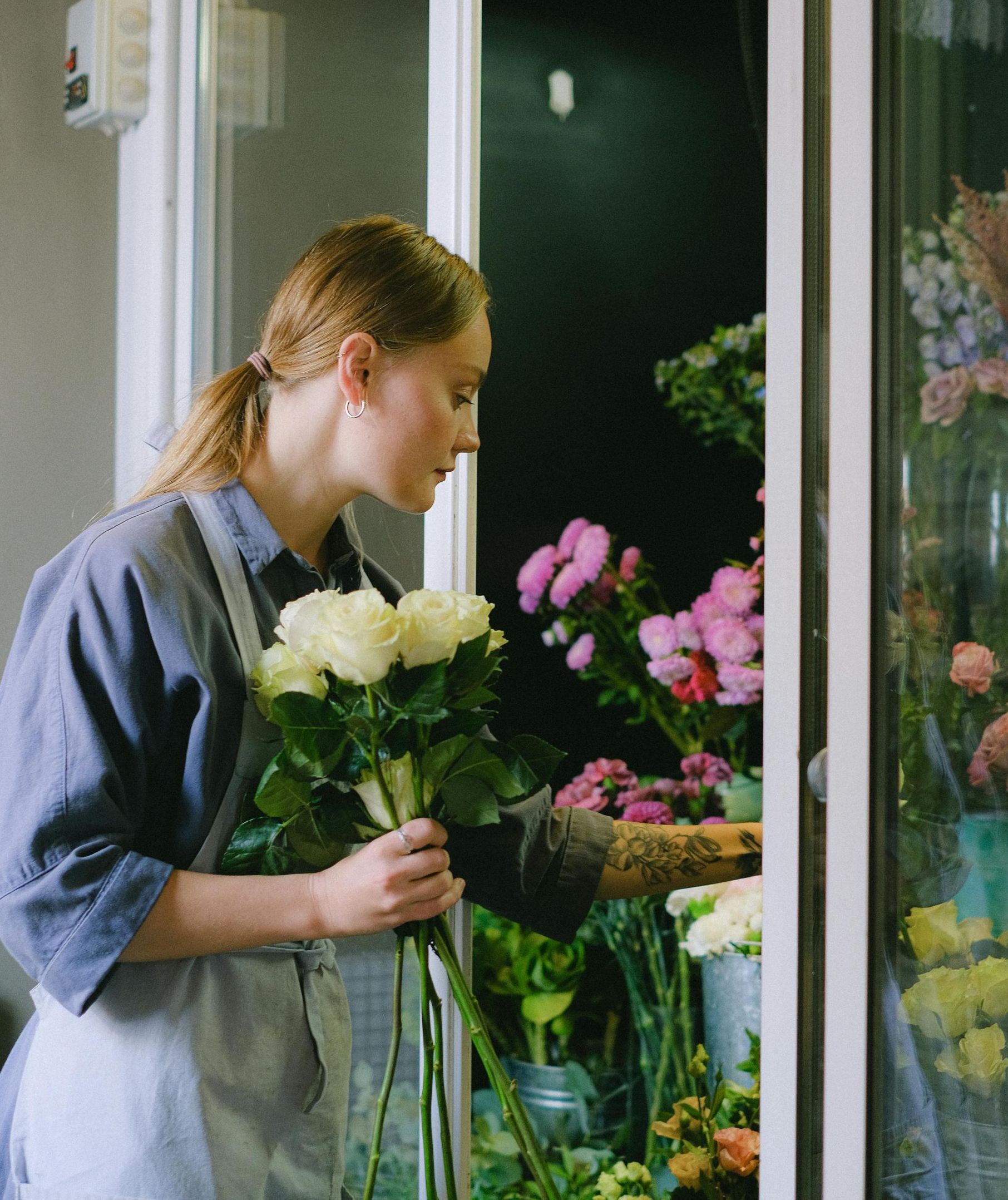 A woman is holding a bouquet of flowers in front of a window