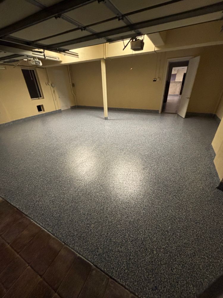A garage with a gray floor and a garage door.