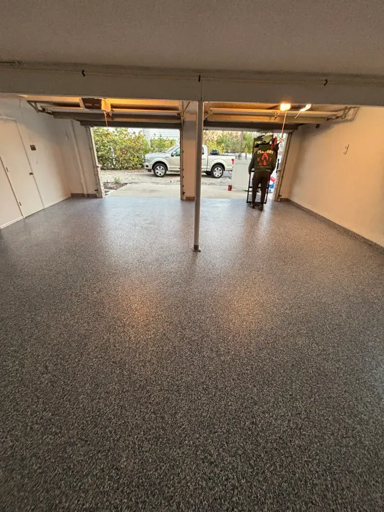A man is standing in a garage with a ladder.