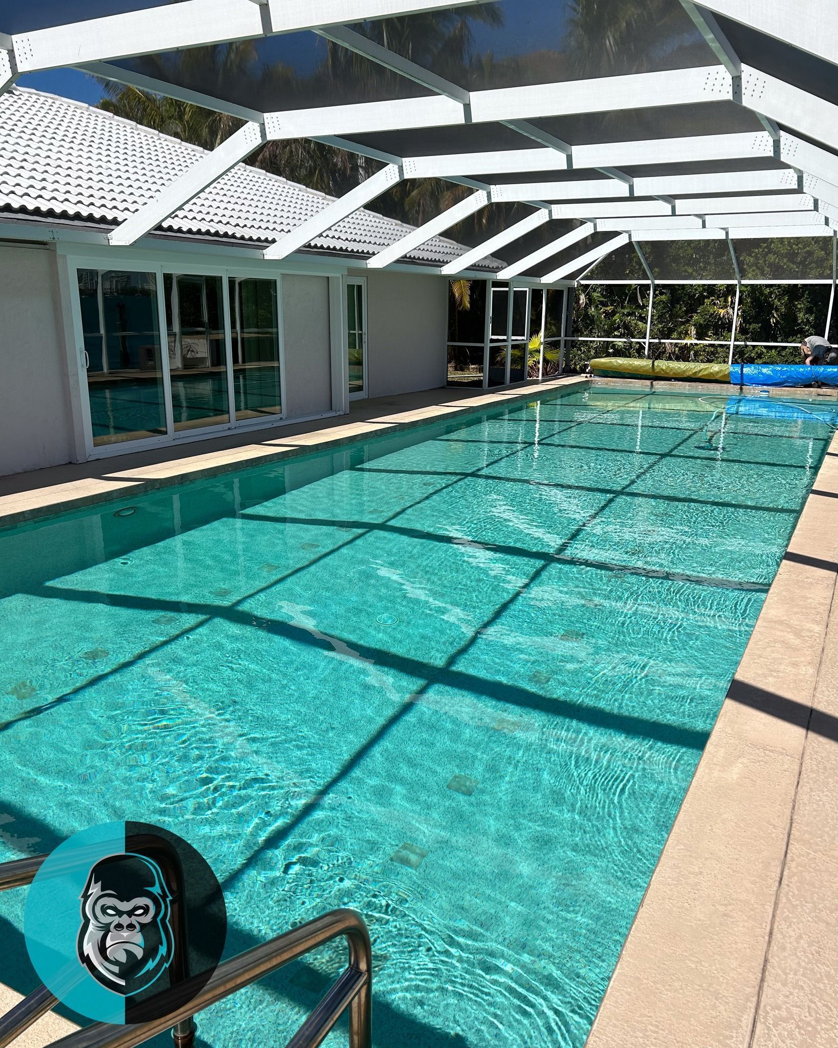 There is a large swimming pool in the backyard of a house.