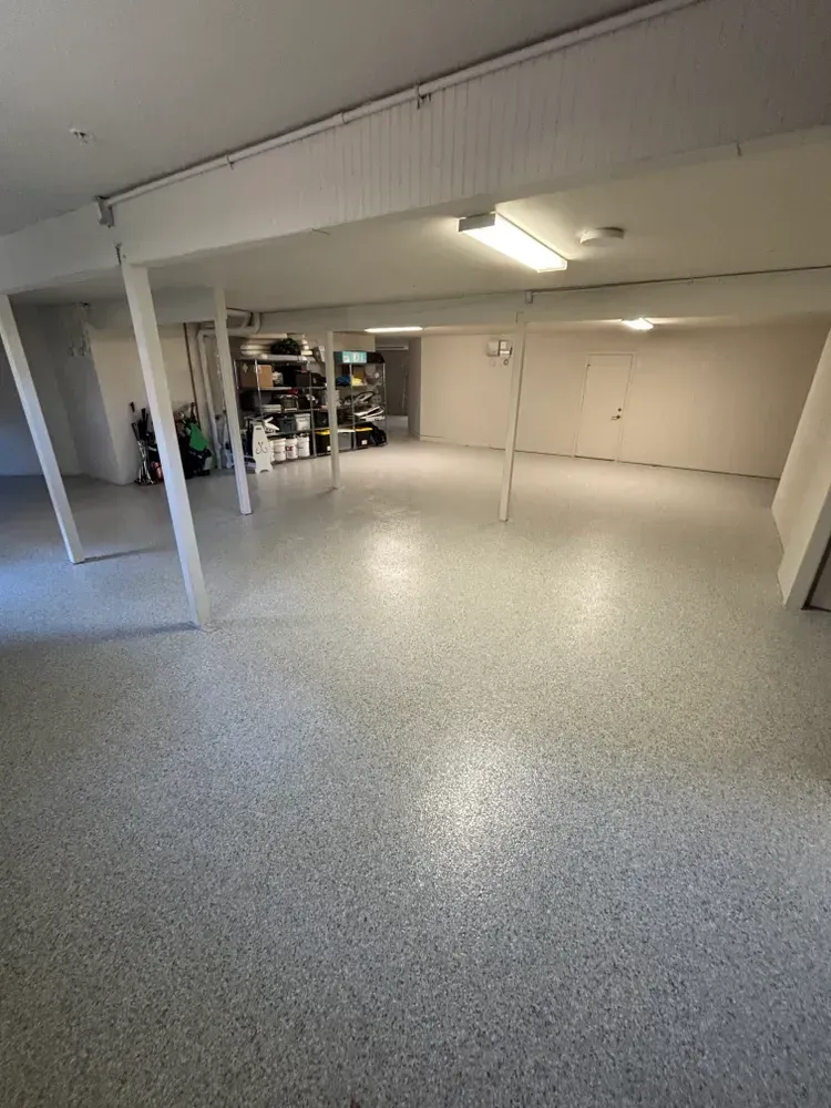A large empty basement with a white floor and white walls.